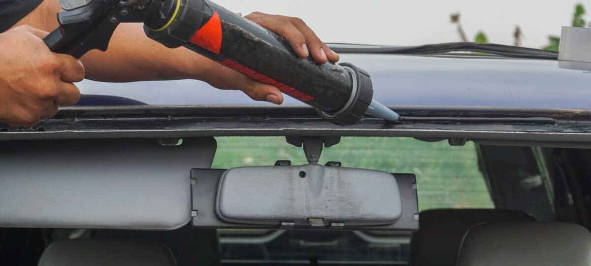 Glazier using tools repairing to fix crack broken windshield,