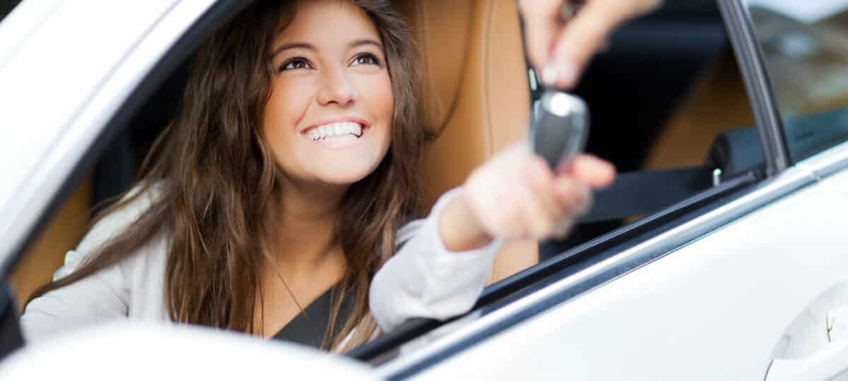 Woman receiving keys of her rental car